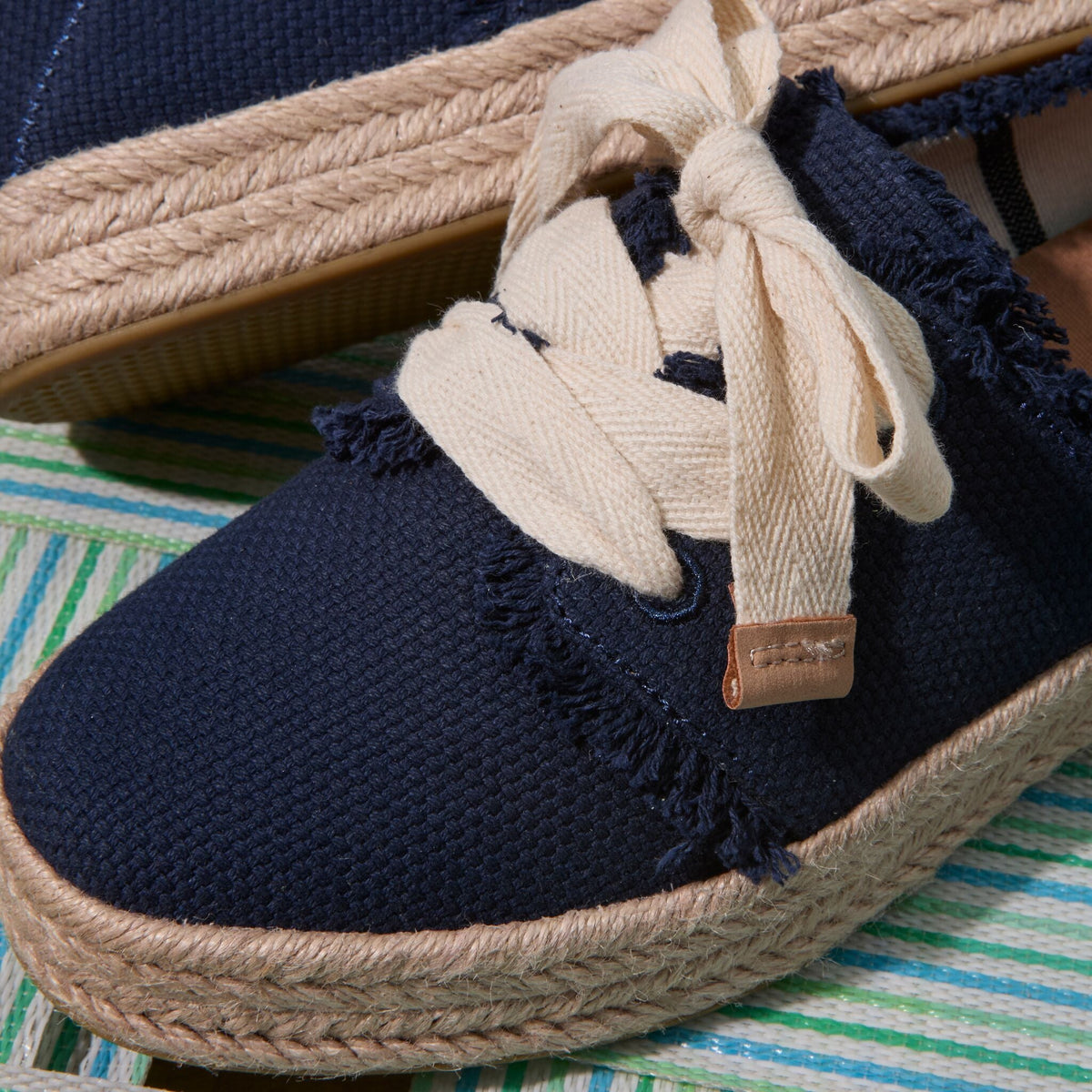 Up close detail shot of the navy frayed Carolina lace up espadrille