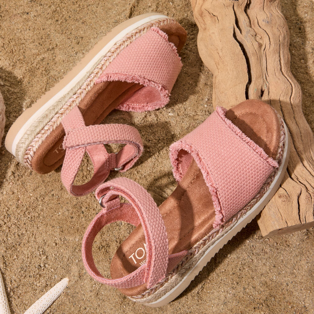 Laydown image on the beach of the Youth Kids Diana sandal in Bloom