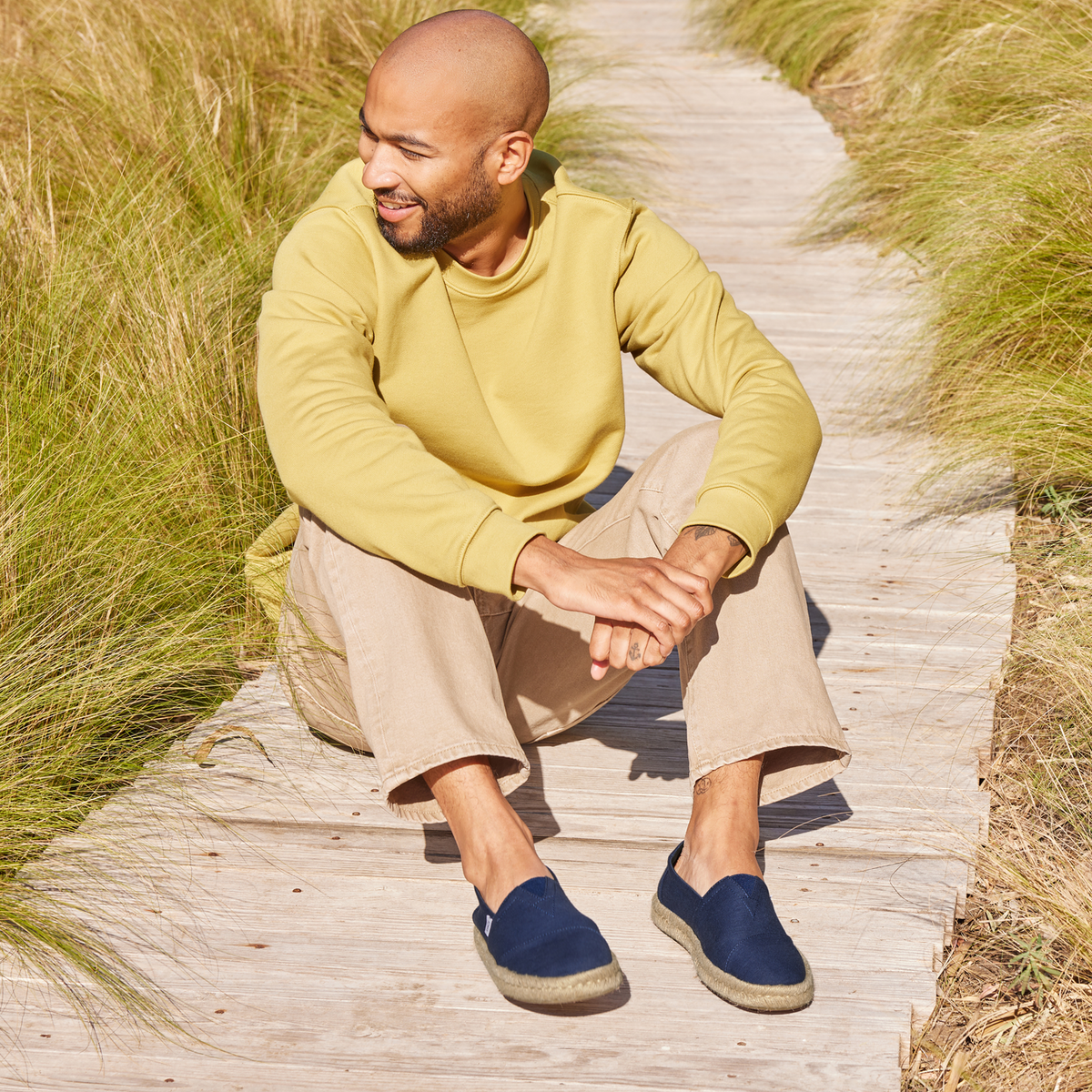 Mens Alpargata Rope Espadrille In Navy Recycled Cotton On Model Sitting On Wooden Walkway