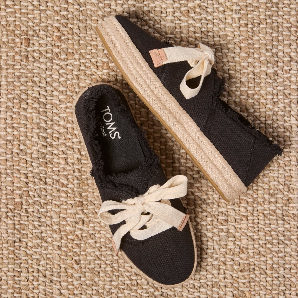 Laydown image of the black beachside woven lace up Carolina Espadrille